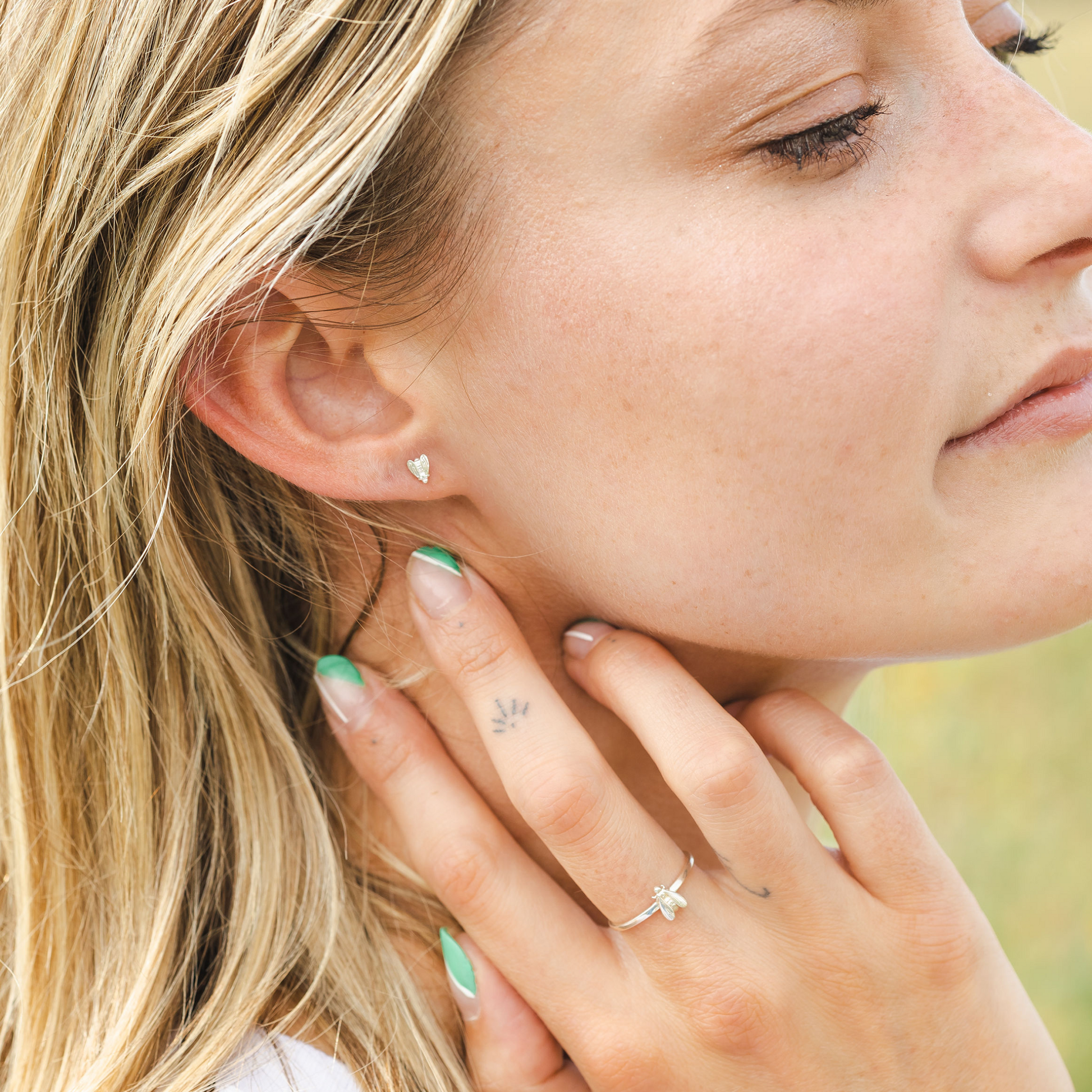woman wearing gold bee earrings
