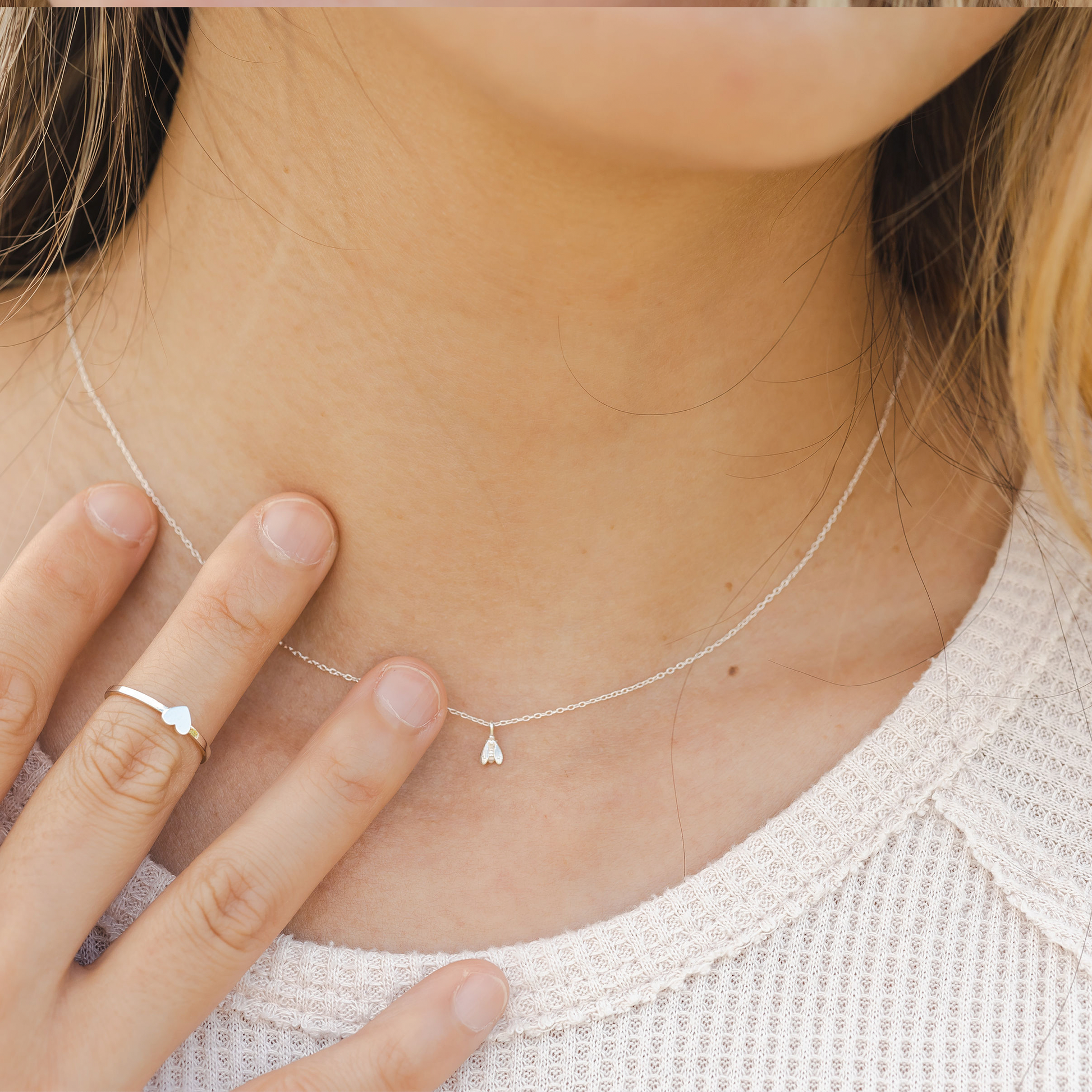 woman wearing gold bee necklace